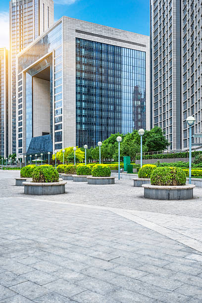 istock green trees and cement floor front of modern buildings 538654308