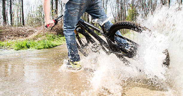 istock Low section of man riding bicycle in water 538657750