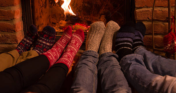 istock Low section of friends resting legs at fireplace 538658212