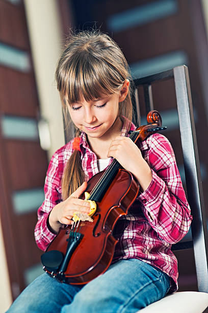 istock Little girl cleaning her violin 538659340