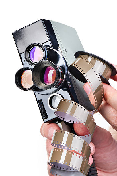 istock Retro mechanical movie camera and film in hands operator isolate 538664816