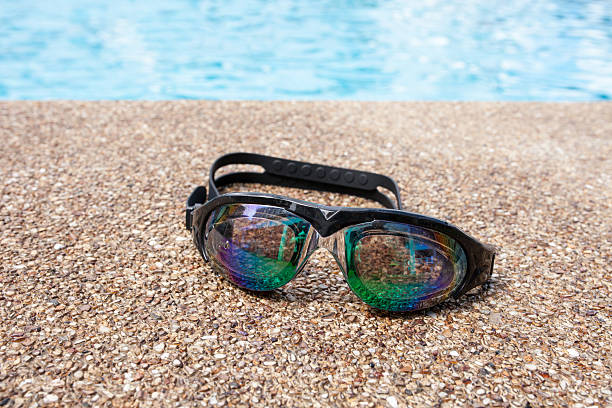 istock Glasses for swimming on a cement floor with small stone 538665772