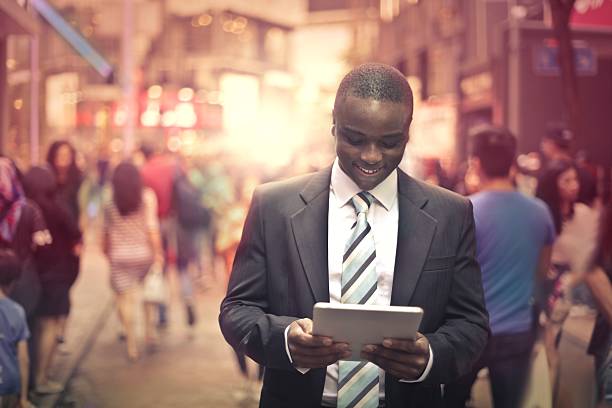 istock Smiling businessman using tablet in the street 538667294