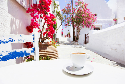 A cup of coffee with Mediterranean town at the background