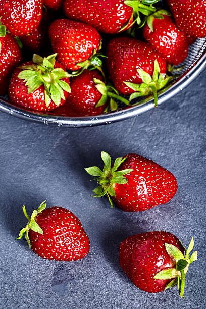 istock Washed strawberries in sieve on stone background 538670816