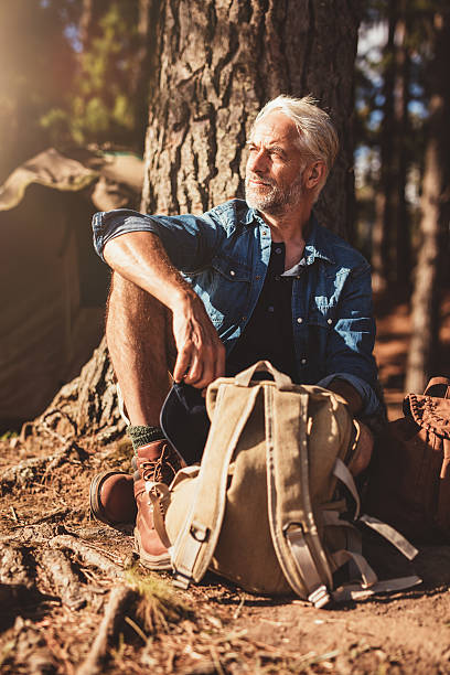 istock Senior man sitting by a tree and looking away 538674104
