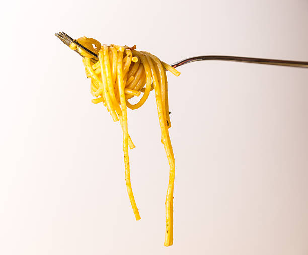 istock Fork full of spaghetti with sauce on white background 538676670