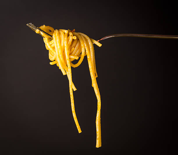 istock Fork full of spaghetti with sauce on black background 538676688