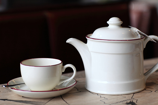 Teapot and the empty cup on a table