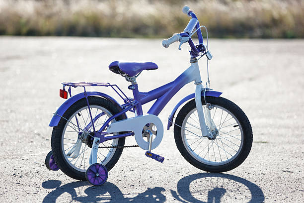 petits enfants vélo avec des roues en plein air. - roue stabilisatrice photos et images de collection