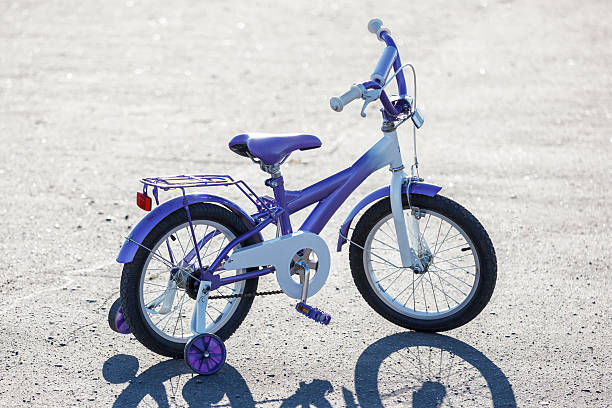 kleine kinder mit dem fahrrad mit ausbildung räder im freien. - stützrad stock-fotos und bilder