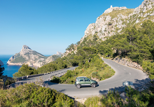 Cap De Formentor, Mallorca, Spain - June 2, 2016: A driver navigating their car around a hairpin bend on the Formentor Peninsula, which makes up the northern tip of the Balearic island of Mallorca.