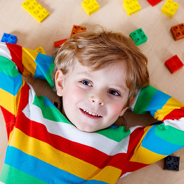 istock Little blond child playing with lots of colorful plastic blocks 538682809