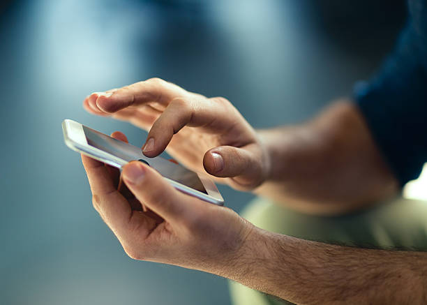 smartphone Male hands typing on smartphone. portable information device stock pictures, royalty-free photos & images