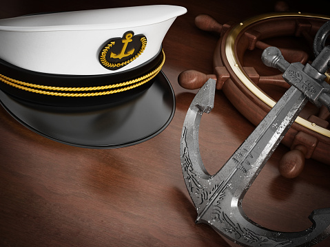 Ship wheel, anchor and sea captain's hat decorated with golden rope, anchor and laurels badge.