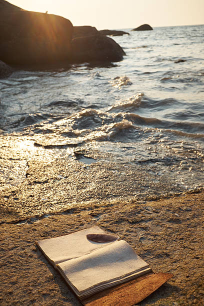 istock tropical sunset rocky beach with old vintage notebook 538684134