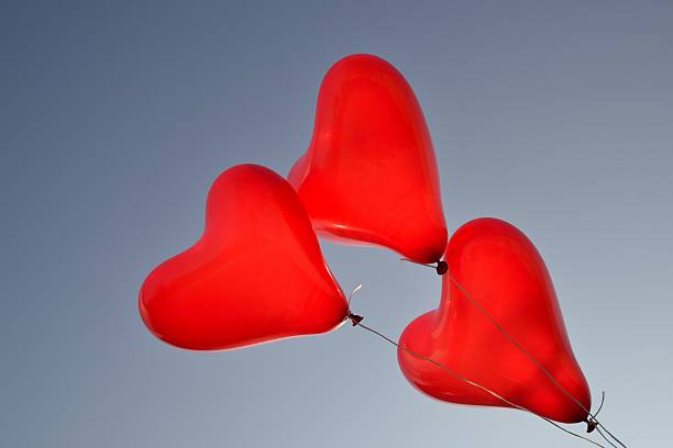 Heart balloons Three red heart - shaped balloons with blue sky valentinstag stock pictures, royalty-free photos & images