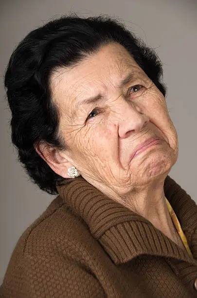 closeup portrait of old cranky grumpy sad woman grandmother