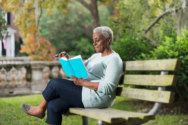 Photo of Senior black woman reading a book