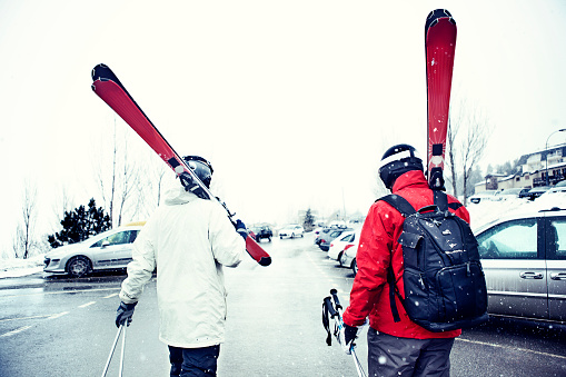 Skiers walking and carrying their skis