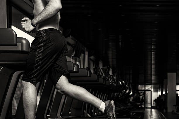 Close Up Of Male Legs Running On Treadmill - Blurred Motion