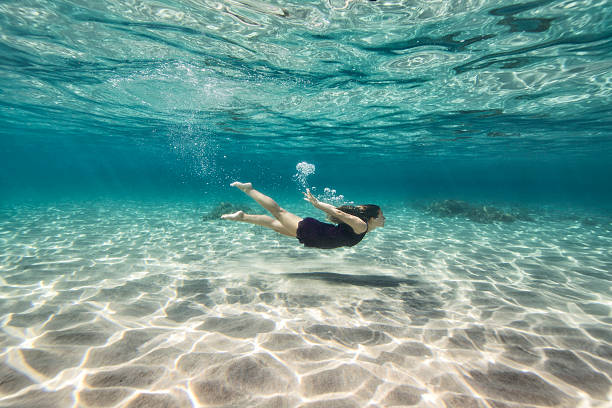 istock Young woman swimming underwater 538703067