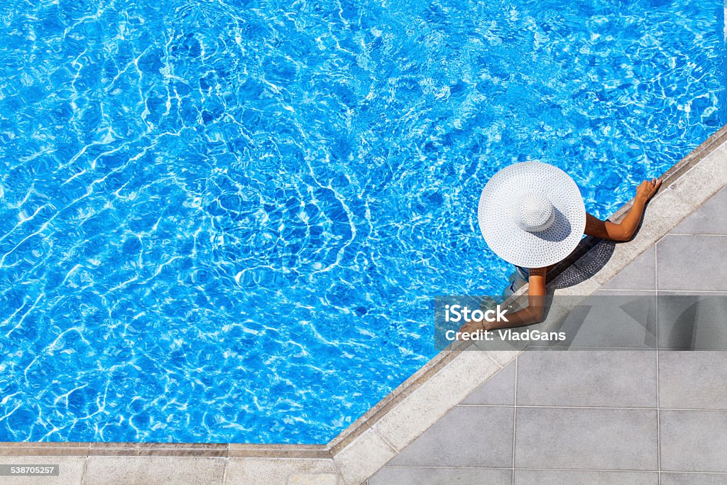 woman relaxing at a resort swimming pool woman relaxing in resort swimming pool Swimming Pool Stock Photo