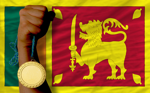 Winner holding gold medal for sport and national flag of sri lanka