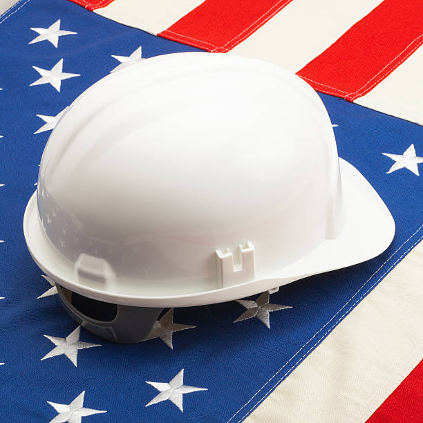 istock White color construction helmet laying over US flag 538707873