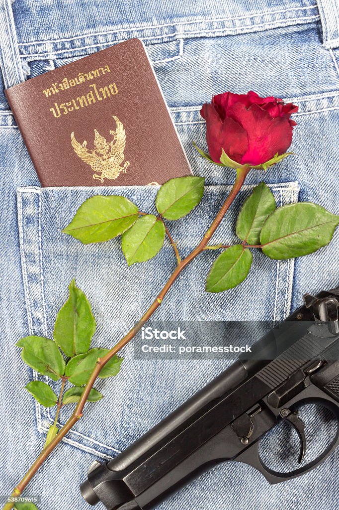 Thai passport gun and rose in jeans pocket 2015 Stock Photo