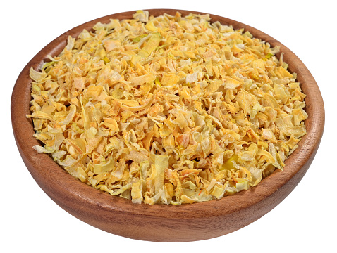 Dried onions in a wooden bowl on a white background