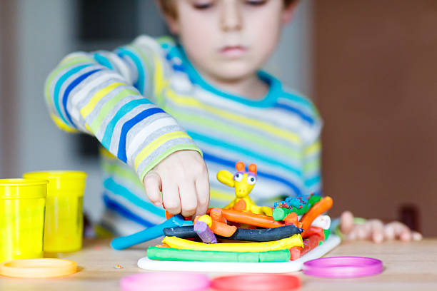 istock Hands of little child playing with dough, colorful modeling comp 538727913