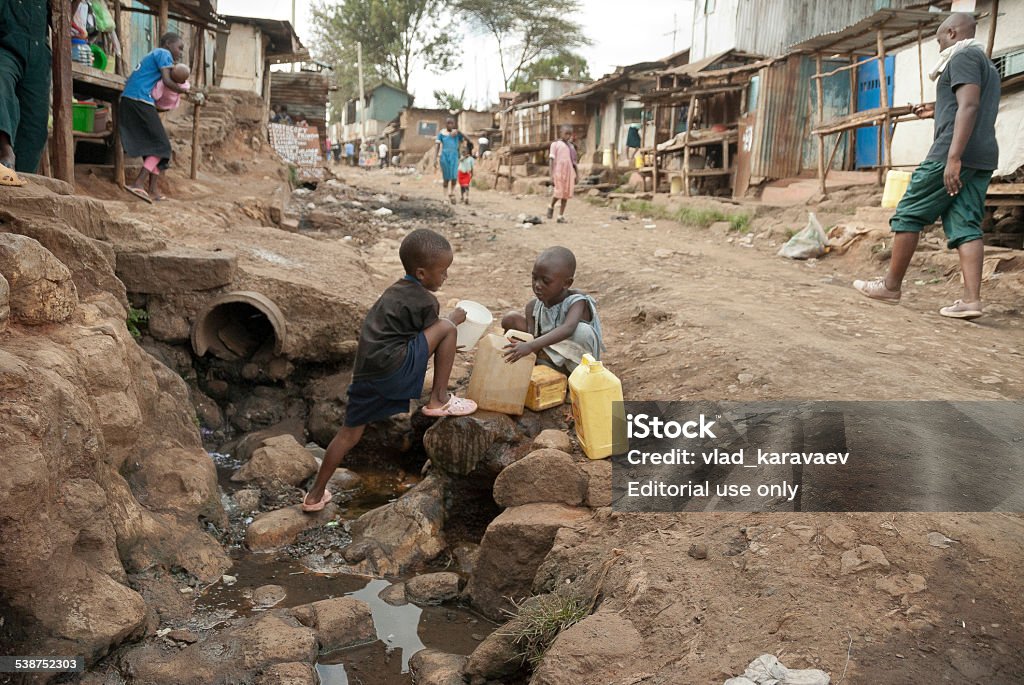 Garçons Prenez l'eau sur une rue de Kibera, Nairobi, Kenya. - Photo de Pauvreté libre de droits