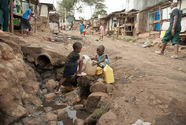 garçons prenez l'eau sur une rue de kibera, nairobi, kenya. - street child photos et images de collection