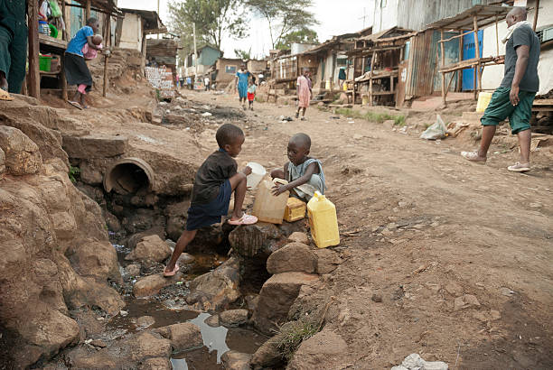 Boys take water on a street of Kibera, Nairobi, Kenya. stock photo