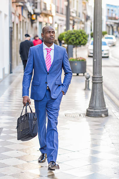istock Black businessman walking on the street with a modern briefcase 538771977