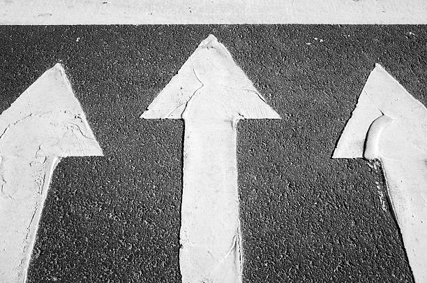 istock White arrows on black highway, road marking 538774186