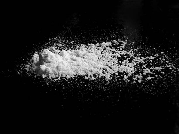 White powder on black surface White powder on black surface, closeup powdered sugar stock pictures, royalty-free photos & images