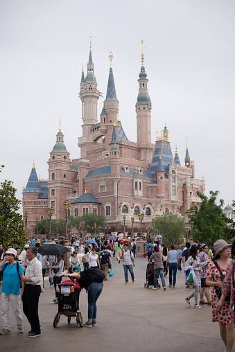 Shanghai, China - June 7, 2016: Happy people near famous castle in Shanghai Disneyland Park, located in Chuansha New Town of Pudong New Area, is officially confirmed to open on June 16th, 2016. Is the sixth in the world and the second in China (after Hong Kong Disneyland).