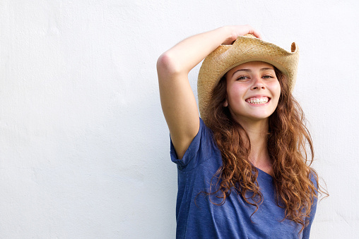 Close up portrait of a smiling young woman with cowboy hat