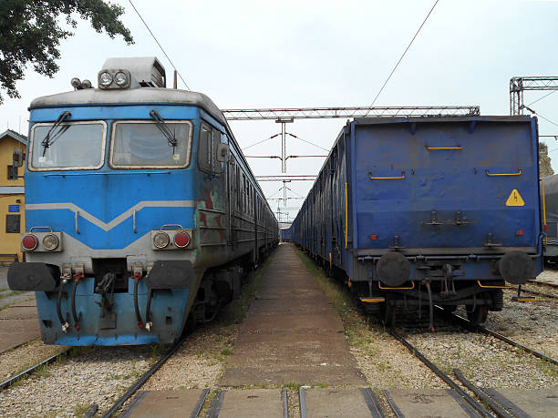 Two blue trains in the railway station, placed in opposite directions.