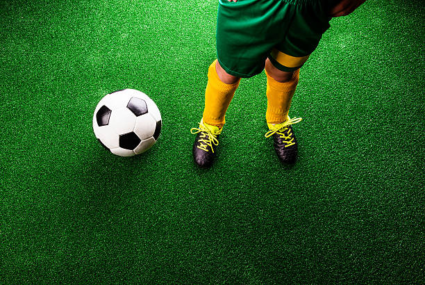 istock Unrecognizable little football player against green grass, studi 538777896