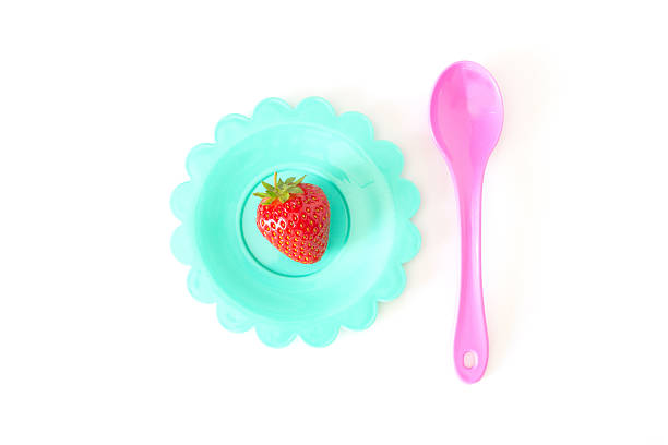 Plate filled with tasty strawberries splashed with milk.