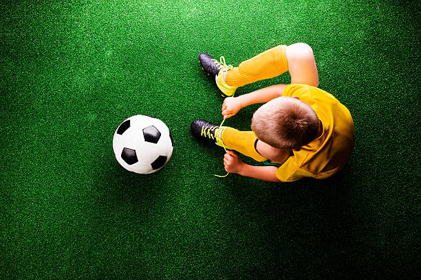 riconoscibile piccolo giocatore di calcio in erba verde, studi - little boys people indoors soccer foto e immagini stock