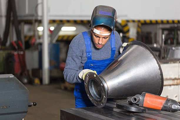 schweißer inspektion metall-stück für qualitätsprüfer - welder manual worker african descent steel worker stock-fotos und bilder