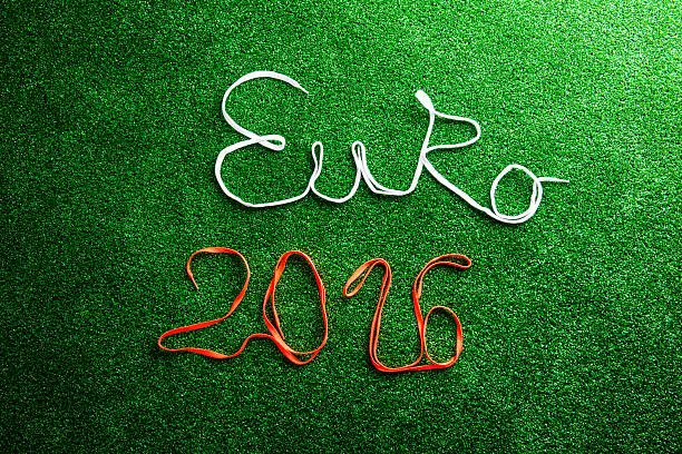 Euro 2016 sign made of shoelaces against artificial turf, studio shot on green background.
