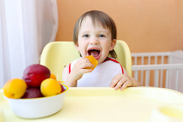 istock happy baby eating fruits 538779775