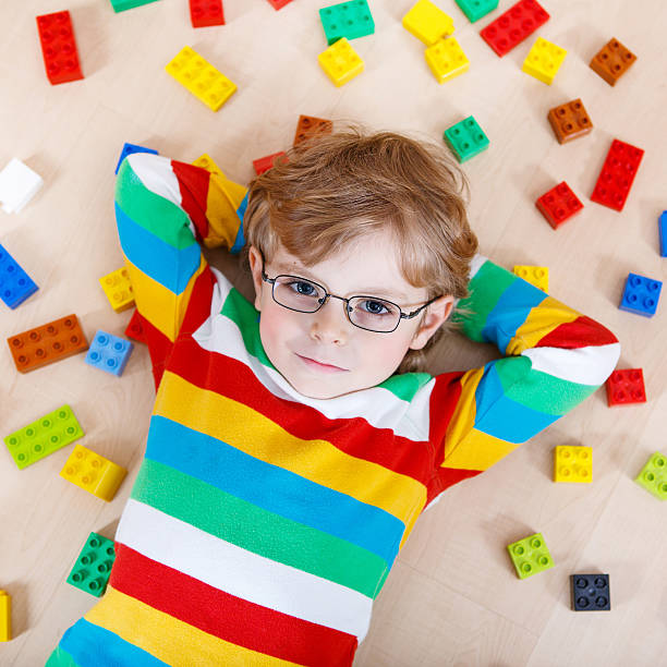 istock Little blond kid boy playing with lots of  plastic blocks 538780369