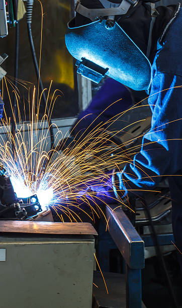 istock welder with protective mask welding metal and sparks 538780537