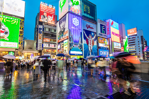 People walking in the centre of Osaka on a rainy night.